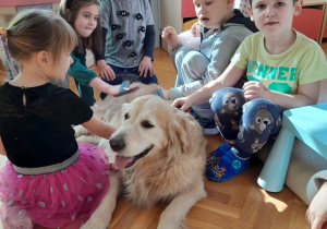 Dzieci głaszczą psa