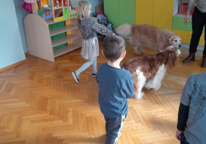 Dzieci prowadzą psa na smyczy