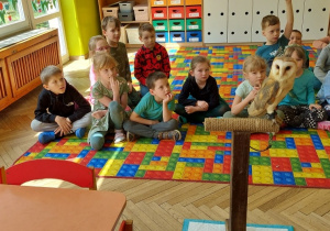 Dzieci podczas warsztatów edukacyjnych z sowami