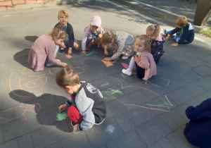 Dzieci rysują kredą na kostce