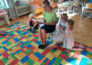 Dzieci słuchają książki czytanej przez gościa
