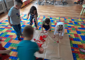 Dzieci układają pomidora z zabawek w odpowiednich kolorach