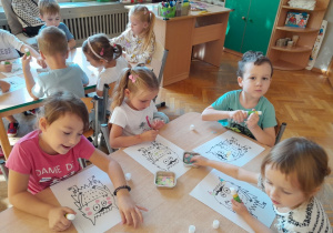 Dzieci ozdabiają kolorowego potwora