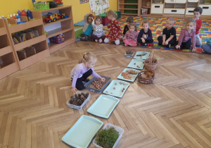 Dzieci wykładają dary jesieni na tacki