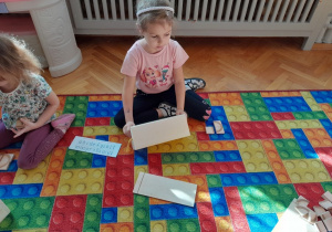 Dziewczynka konstruuje z klocków literę "a"