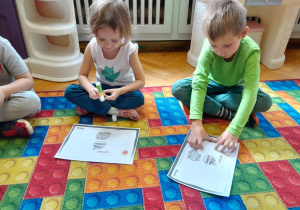 Dzieci przyklejają kolejne warzywo do książeczki projektowej
