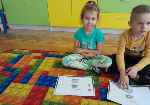 Dzieci przyklejają kolejne warzywo do książeczki projektowej