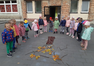Dzieci układają drzewo z darów jesieni