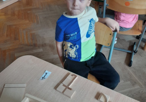 Chłopiec prezentuje skonstruowaną literę "t"