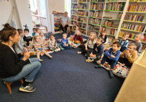 Dzieci słuchają czytanego przez panią bibliotekarkę opowiadania