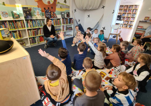 Dzieci słuchają czytanego przez panią bibliotekarkę opowiadania