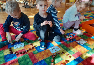 Dzieci układają wzory z kasztanów