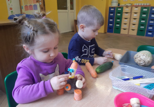 Dzieci tworzą stworki z przyniesionych warzyw