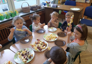Dzieci robią szaszłyki z owoców