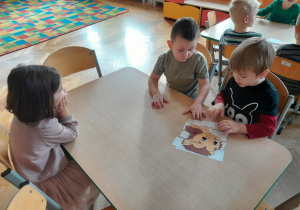Dzieci układają puzzle z jeżem