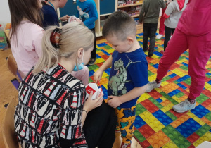 Dzieci pokazują na modelu szczęki, w jaki sposób myć zęby
