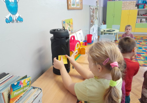 Dzieci szukają w sali przedmiotów wykorzystujących energię elektryczną