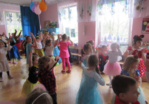 Dzieci tańczą z podniesionymi rekoma