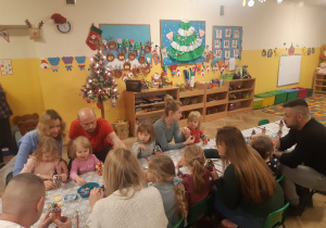Dzieci wraz z rodzicami tworzą ozdoby bożonarodzeniowe