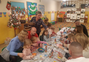 Dzieci wraz z rodzicami tworzą ozdoby bożonarodzeniowe