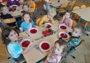 Dzieci jedzą barszcz czerwony