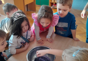Dzieci z nauczycielem wykonują eksperyment "Eko plastik"