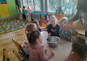 Dzieci z nauczycielem wykonują eksperyment "Eko plastik"