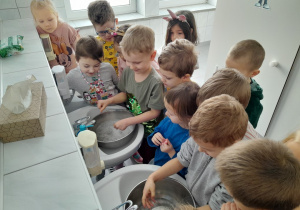 Dzieci podczas doświadczenia "Oszczędzamy wodę podczas mycia rąk"