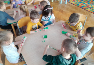 Dzieci malują farbami papierowe rolki
