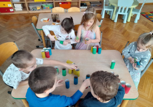 Dzieci tworzą papierowe klocki