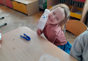 Dzieci tworzą grzechotki z plastikowych butelek