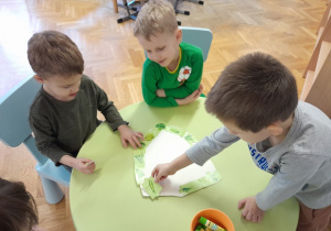 Chłopcy układają puzzle z zielonych warzyw