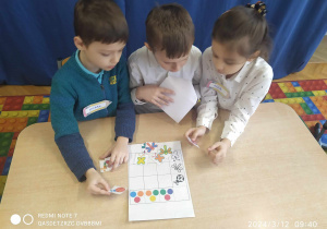 Dzieci rozwiązują zadanie matematyczne z elementami kodowania