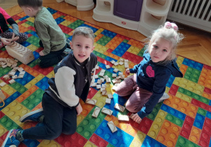 Dzieci konstruują z klocków literę "c"