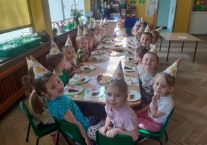 Dzieci jedzą urodzinowy tort