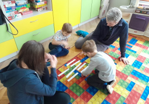 Dzieci z rodzicami układają puzzle