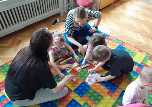 Dzieci z rodzicami układają puzzle