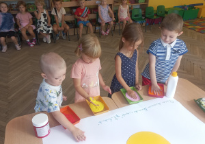 Arek, Aniela, Helena i Maxim maczają dłonie w farbie