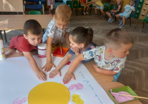 Artem, Mateusz, Emilia i Franek C. odciskają dłonie w farbie