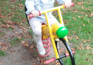Dziewczynka jeździ na motorku.