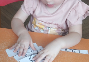 Dziewczynka układająca puzzle.