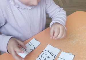 Dziewczynka układająca puzzle chłopca.