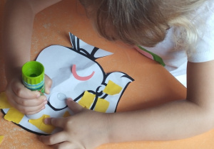 Dziewczynka wykleja portret dziewczynki.