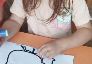 Dziewczynka wykleja portret.