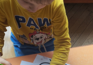 Chłopiec wykleja włosy papierem kolorowym.