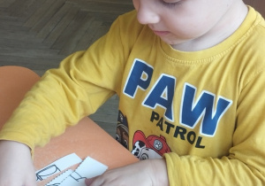 Chłopiec układa puzzle.