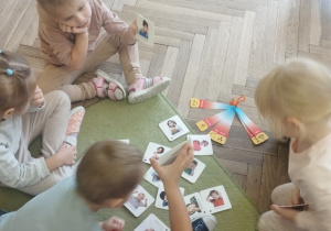 Dzieci oglądają obrazki z emocjami na twarzy dzieci.