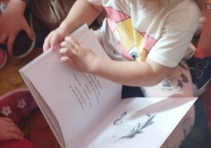 Dziewczynka i chłopiec oglądają książkę.