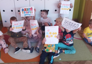 Wspólne zdjęcie grupy z pracami plastycznymi.