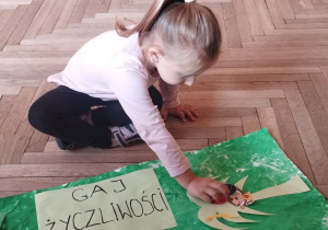 Dziewczynka przykleja małpce banana.